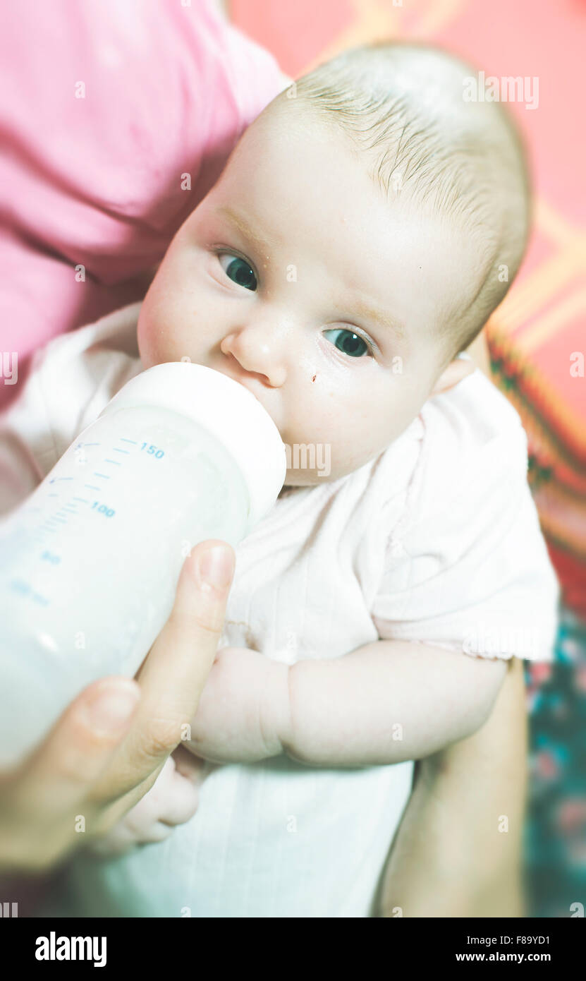 Baby saugt an einer Flasche. Baby in Mutters Händen Stockfoto