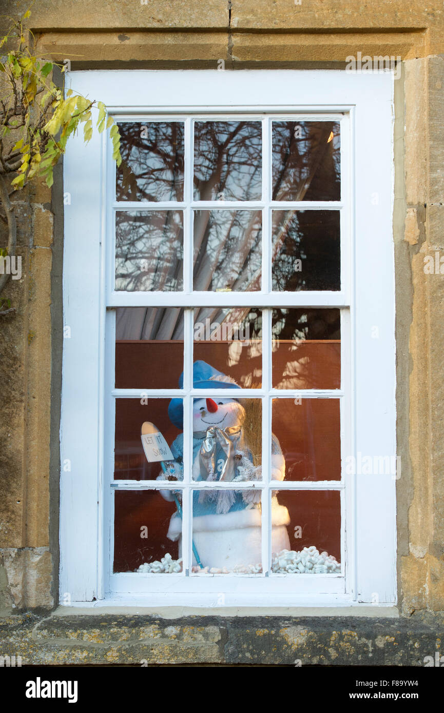 Weihnachten-Schneemann "lassen Sie es Schnee" Schaufenster in Broadway, Cotswolds. England Stockfoto
