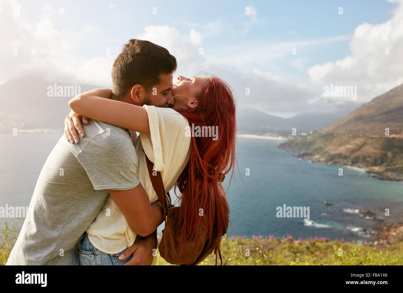 Junges Liebespaar umarmen und küssen auf einen Tag im Freien. Mann umarmt seine Freundin. Genießen ihren Sommerurlaub. Stockfoto