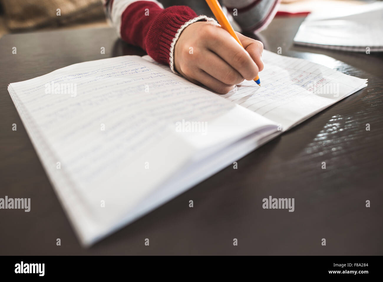 Kind in ein Notizbuch schreiben. Nahaufnahme, Hand und Feder Stockfoto