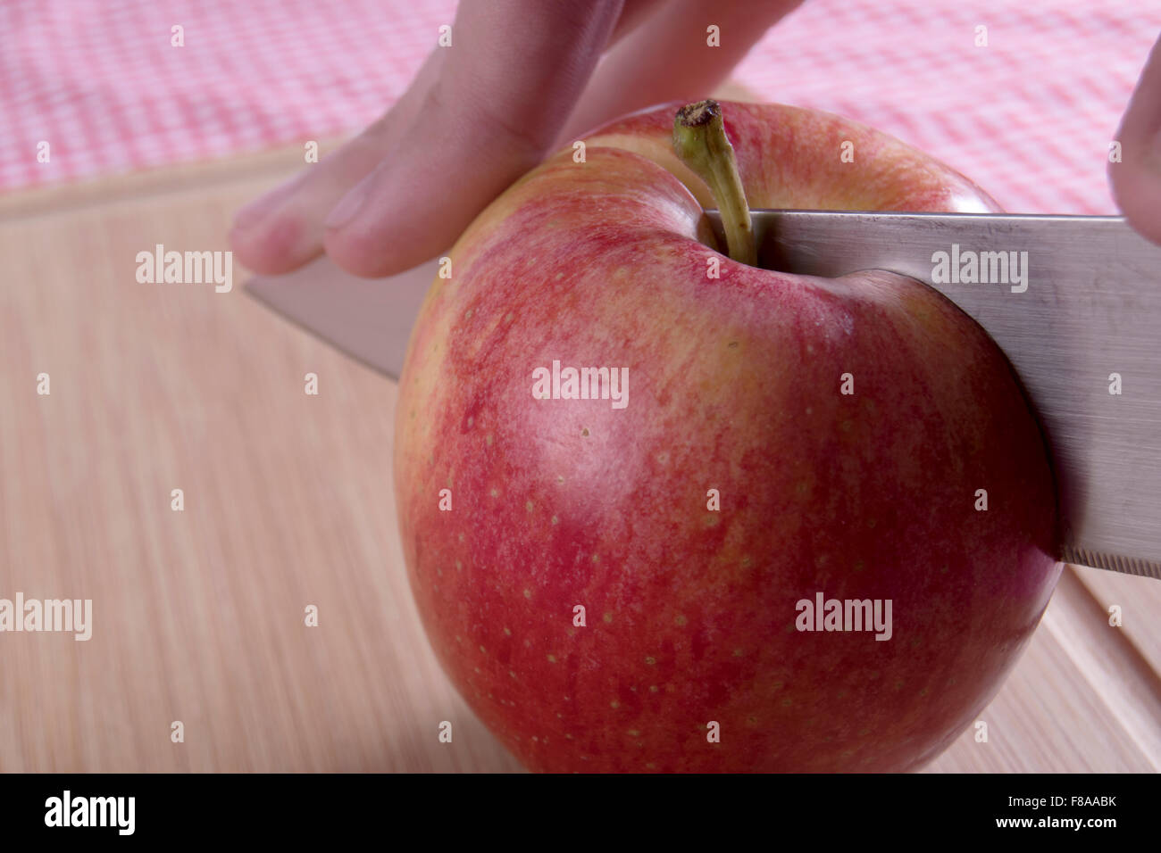 Apfel mit Messer halbieren Stockfoto