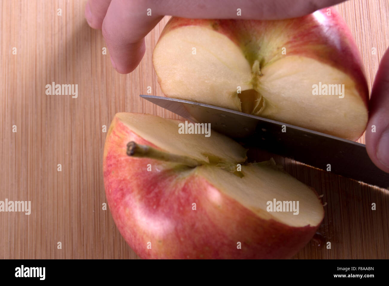 Apfel mit Messer halbieren Stockfoto