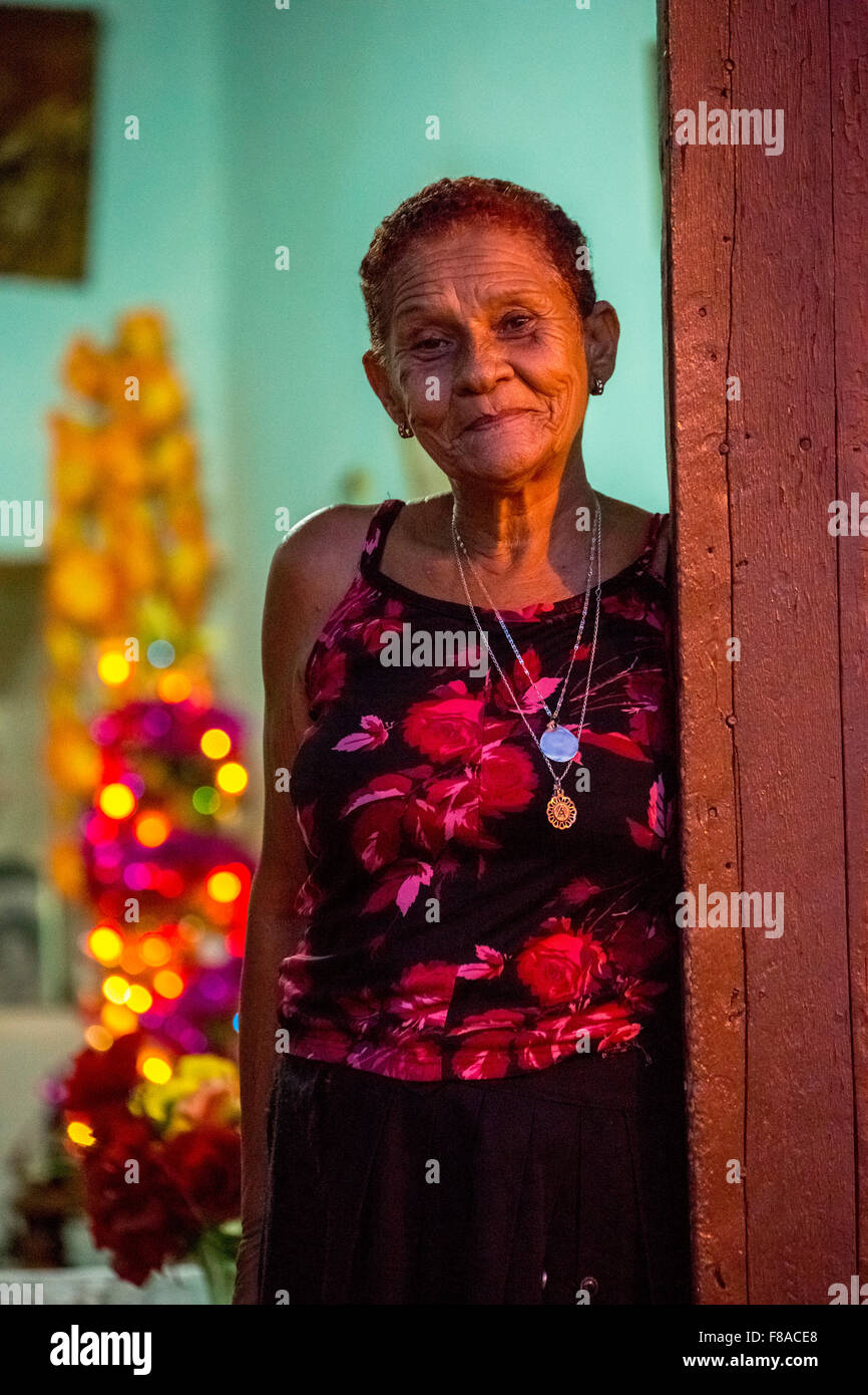 alte Dame sieht freundlich aus ihrer Haustür, Straßenszene in der alten Stadt von Trinidad, Trinidad, Kuba, Sancti Spíritus, Kuba, Stockfoto