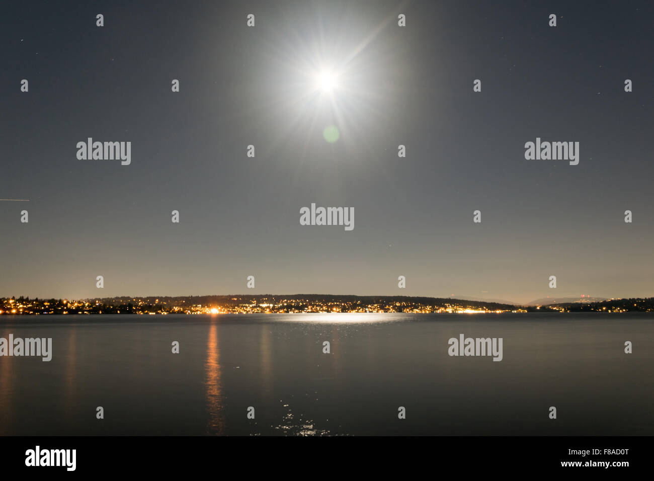 Ein hoher Dynamikbereich Schuss von einem hellen Mond über einen städtischen See. Stockfoto