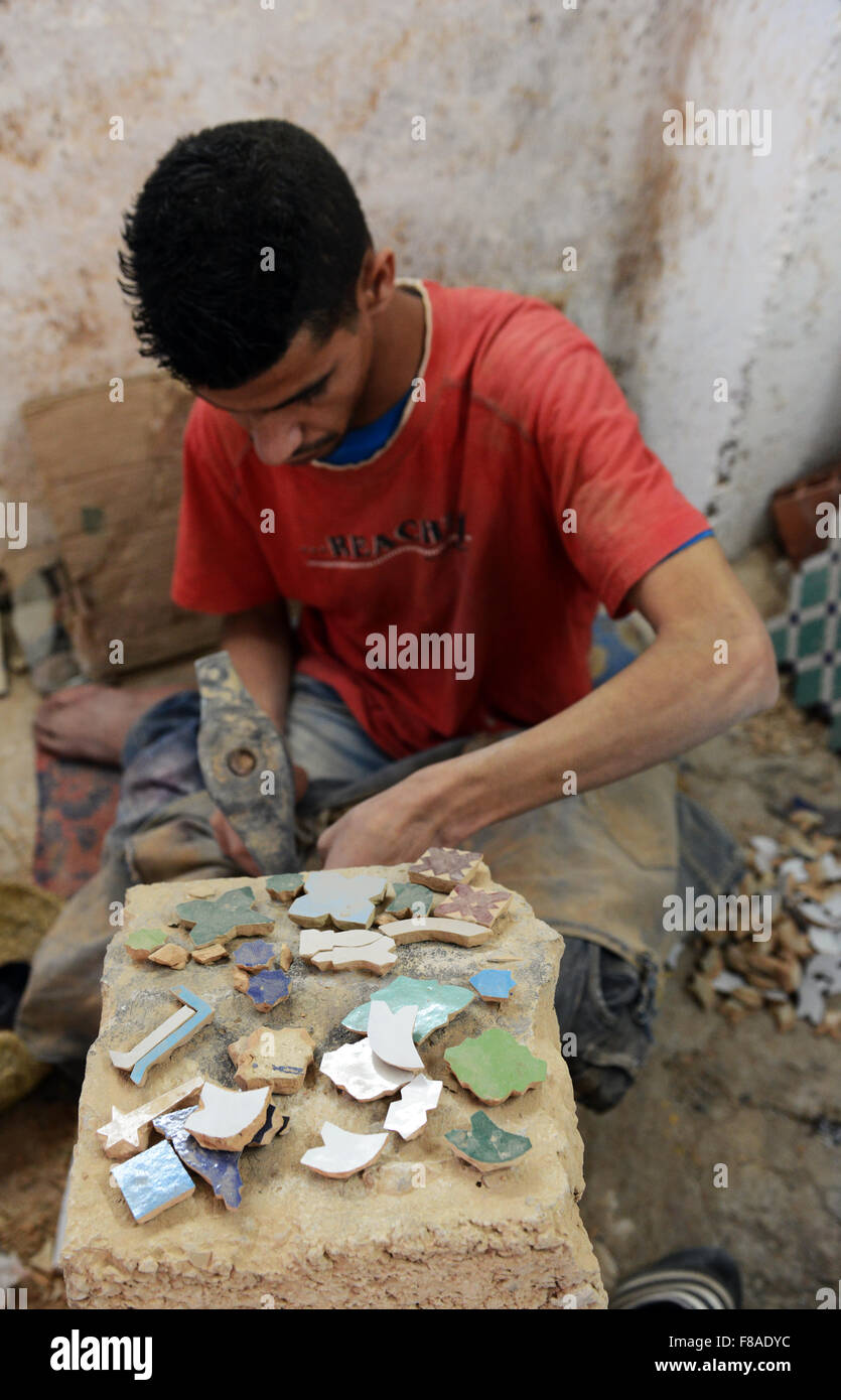 Marokkanische Handwerker Meißeln glasierte Terrakotta-Stücke für Zellige eigelegten. Stockfoto