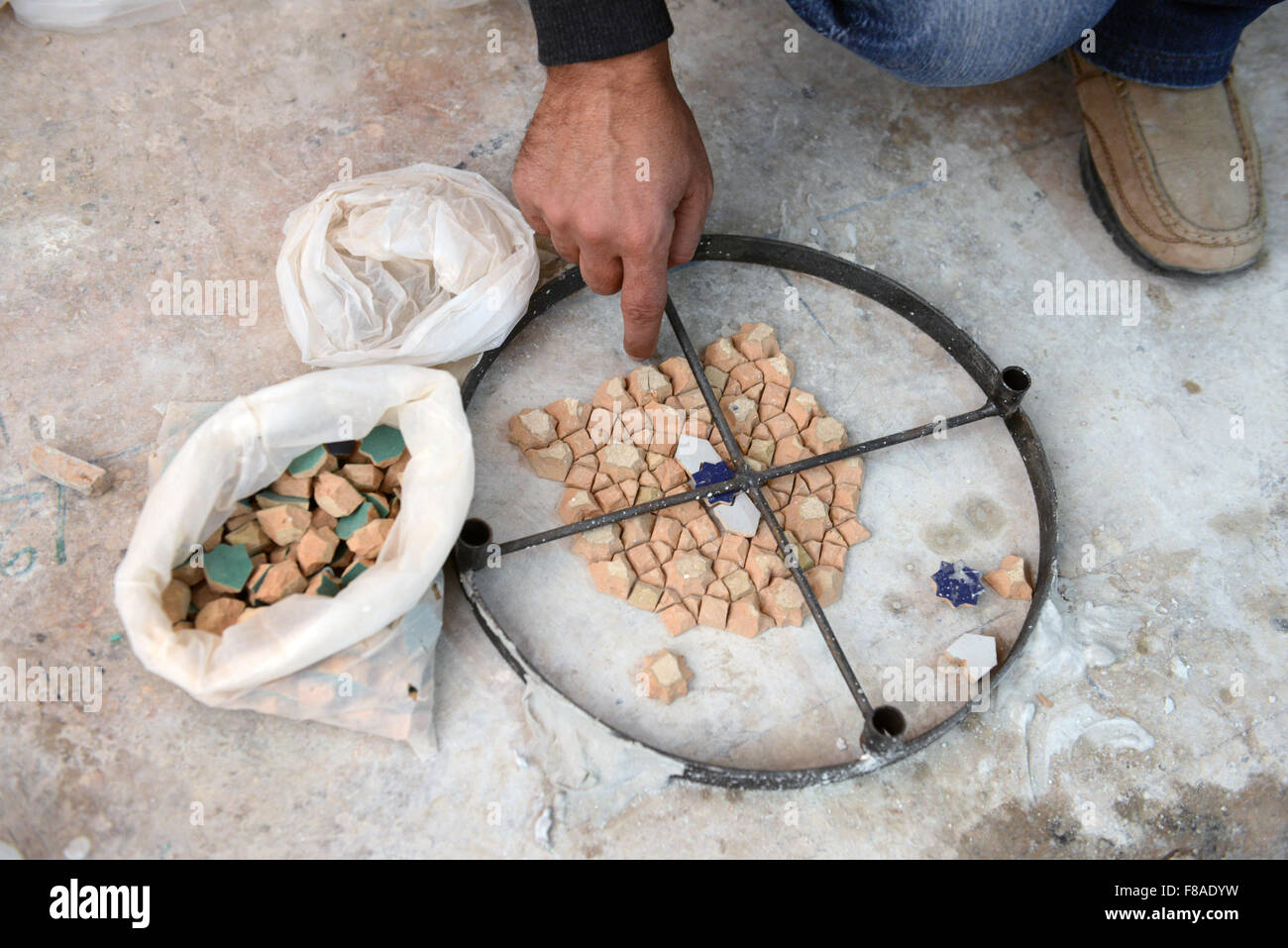 Eine marokkanische Handwerker Vermittlung von Terra Cotta Stücke für Zellige eigelegten. Stockfoto