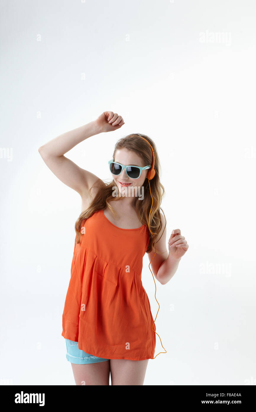 Tanzende Frau in orange ärmelloses shirt Stockfoto