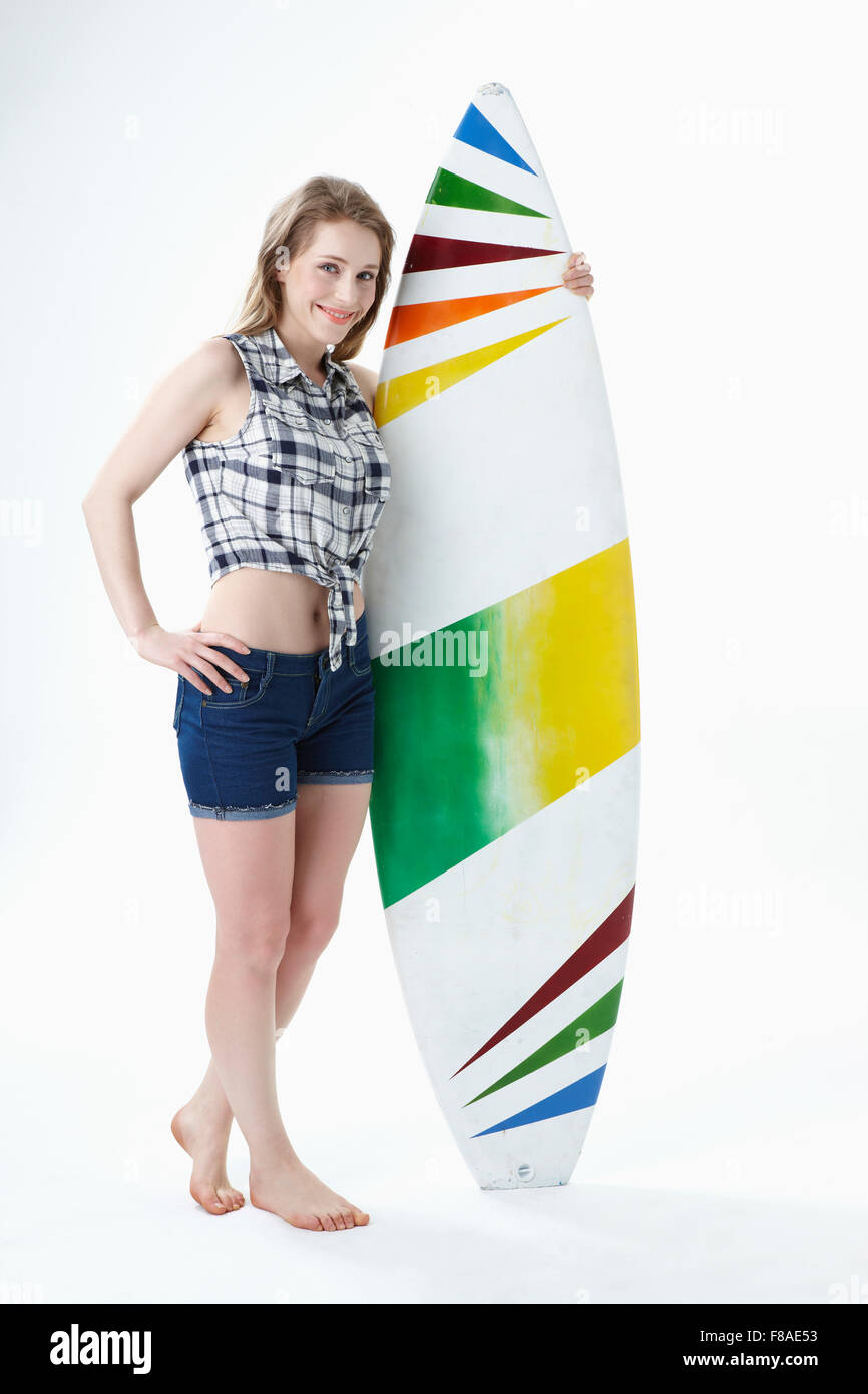 Lächelnde Dame mit ein Surf-Brett holding Stockfoto