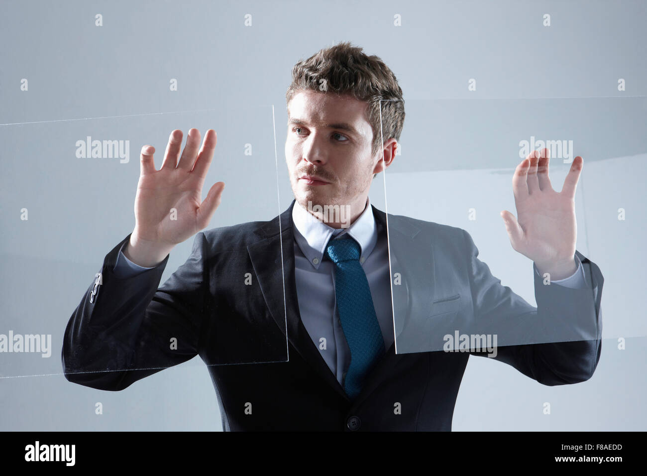 Business-Mann berühren zwei transparente Bildschirme Stockfoto