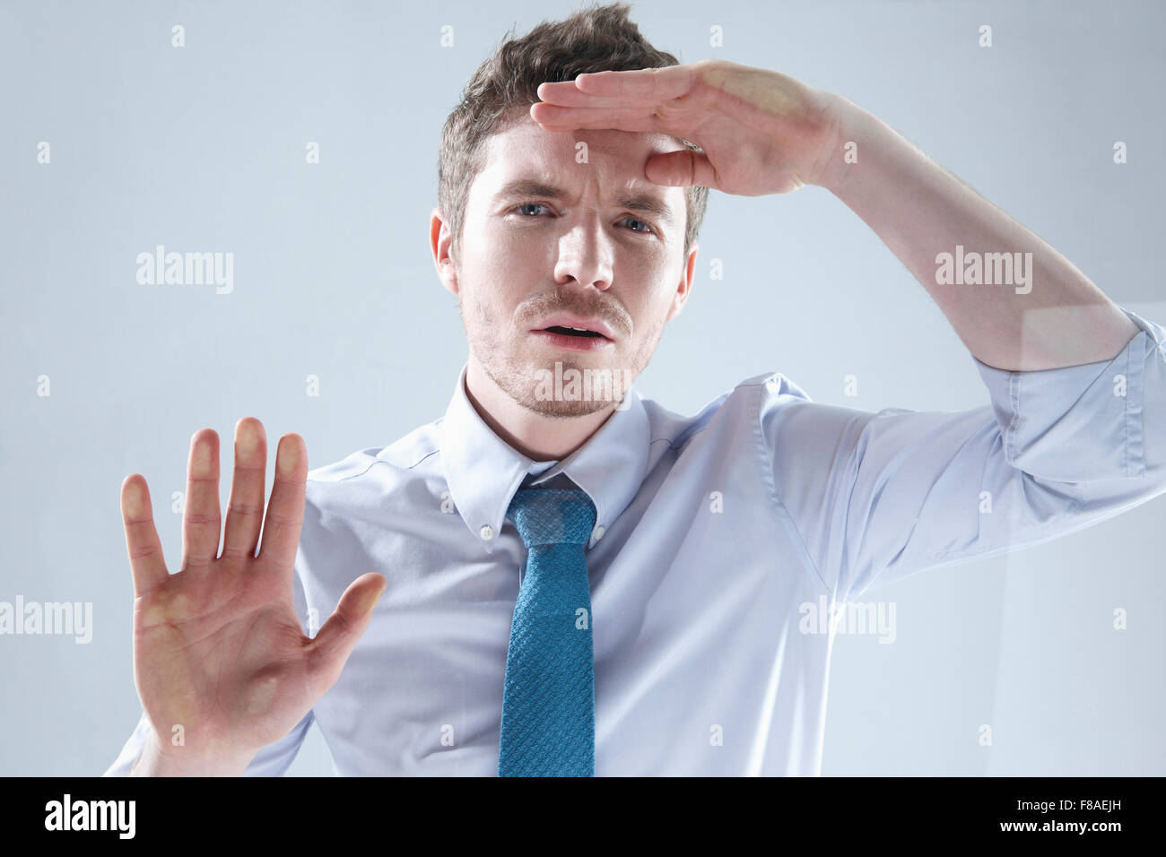 Mann runzelte die Stirn sein Gesicht beim Blick durch das Fenster Stockfoto