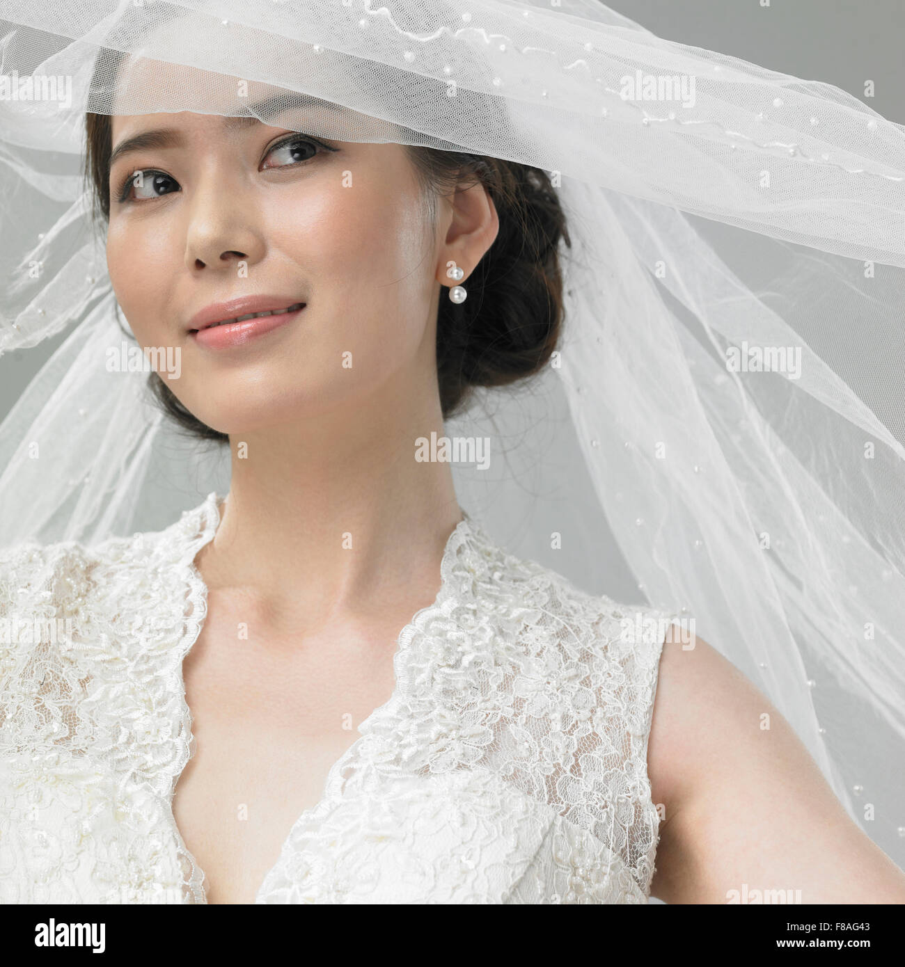 Frau im Hochzeitskleid mit Hochzeitsschleier geöffnet Stockfoto