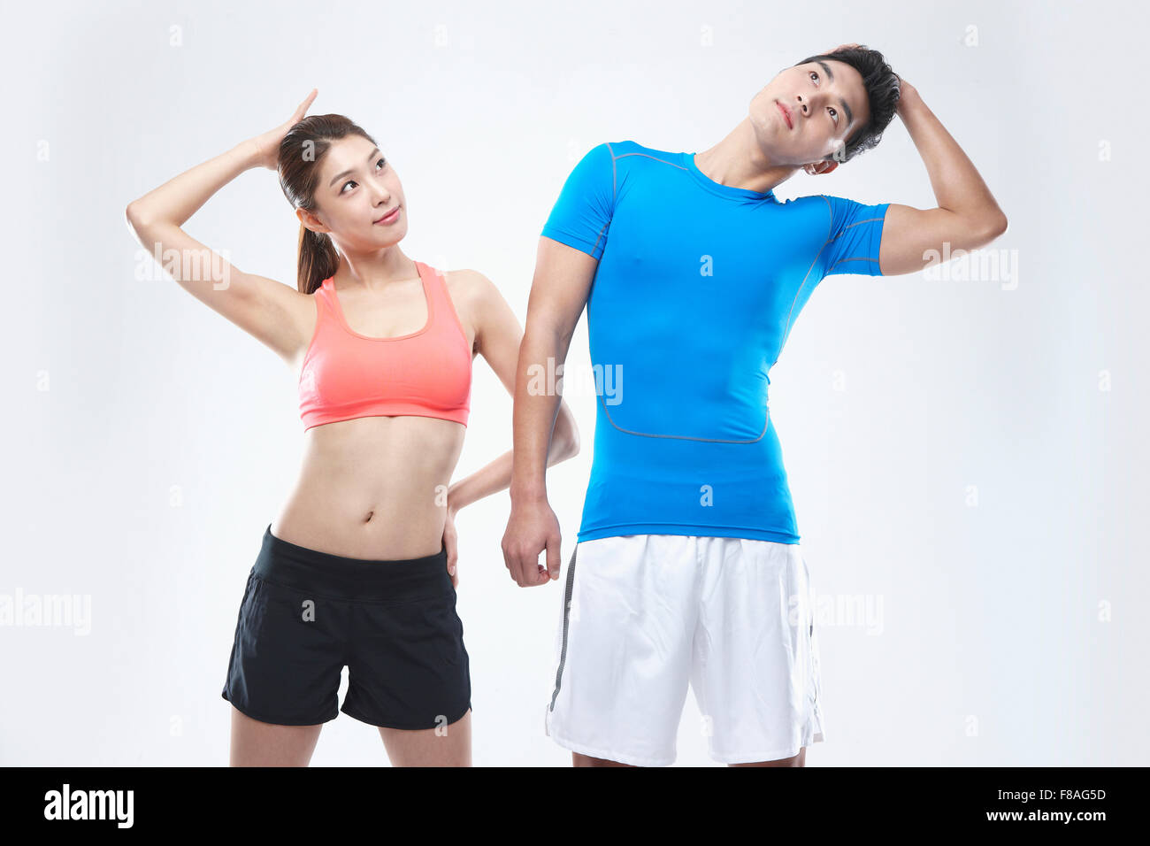 Ein paar im Sport tragen dehnen Hälse nebeneinander Stockfoto