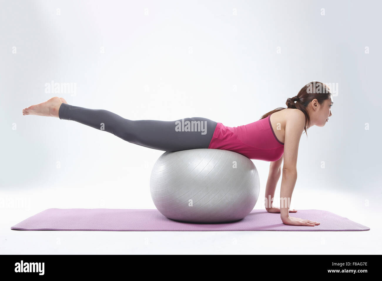 Frau liegend auf Vorderseite auf Gymnastikball gelegt auf Yoga-Matte Stockfoto