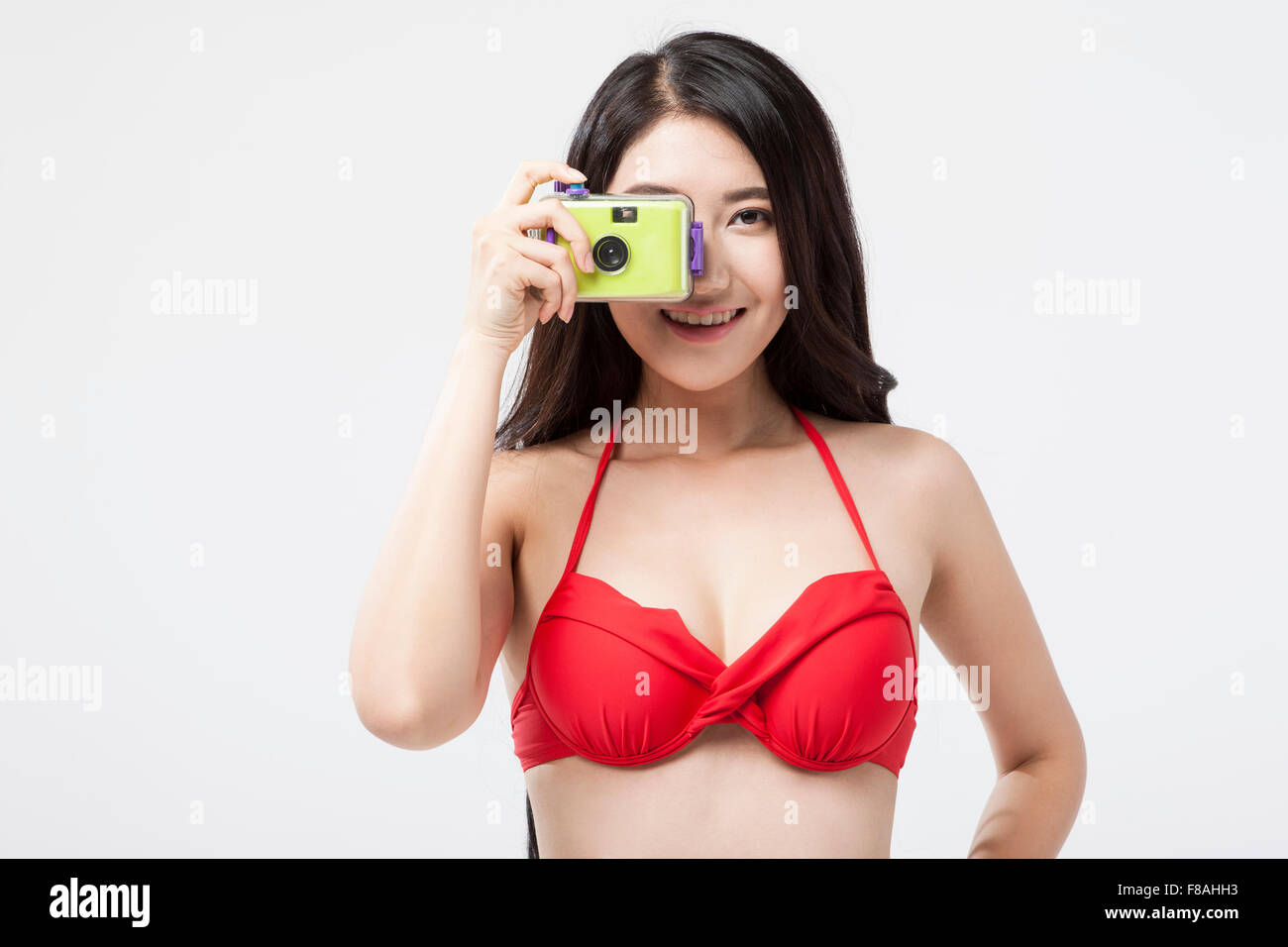 Asiatische Frau im roten Bikini-Oberteil mit einer Kamera fotografieren Stockfoto
