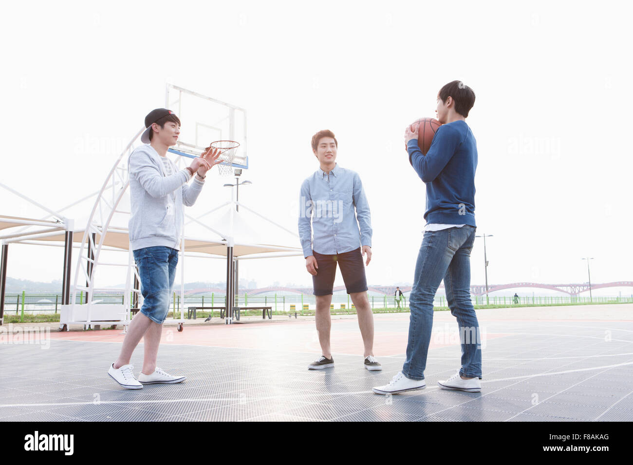Drei junge Männer stehen auf dem Basketballplatz Stockfoto