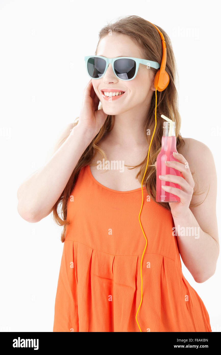 Junge Frau in orange ärmelloses Shirt mit einer Flasche Getränk Stockfoto