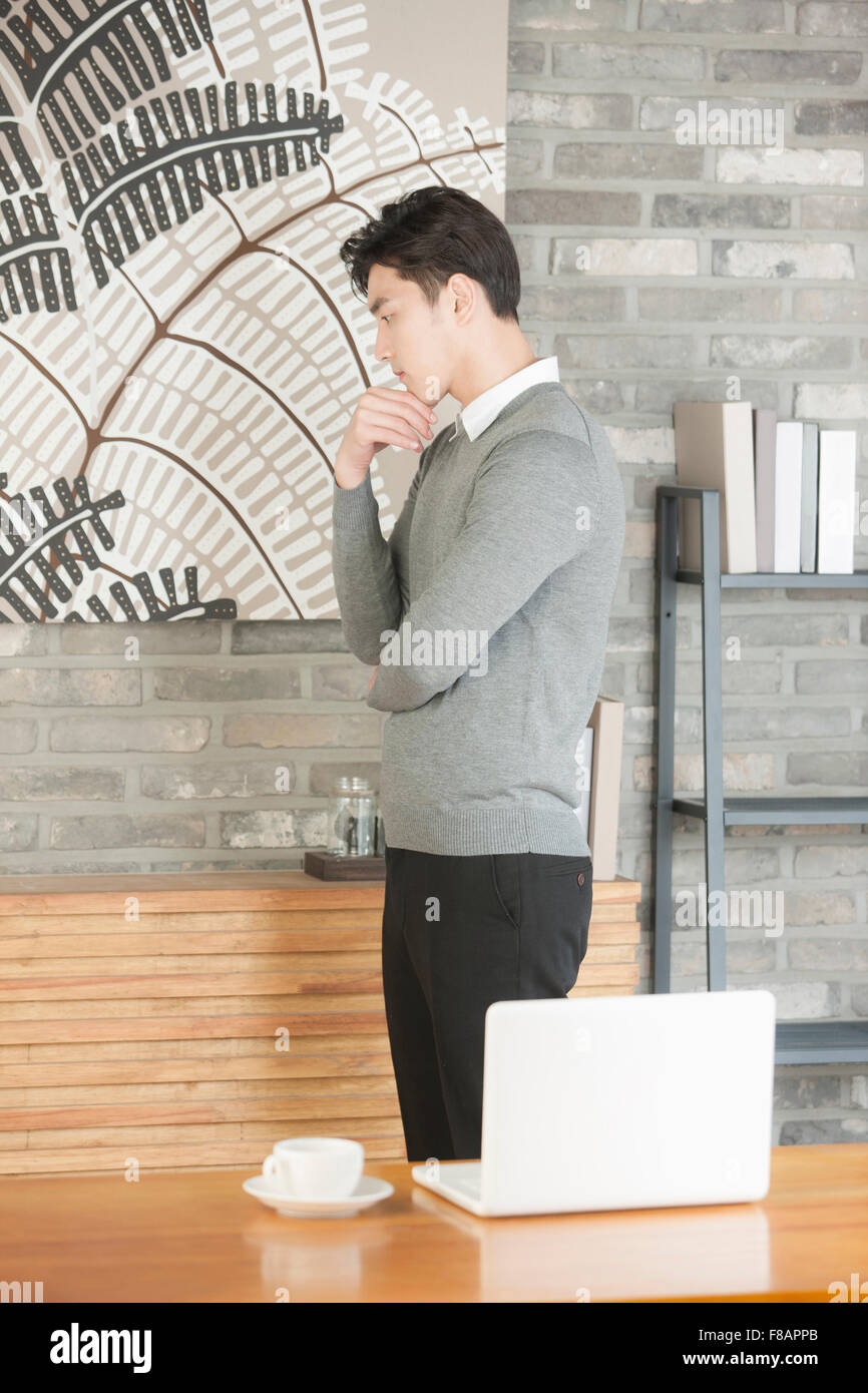 Seitenansicht der junge Geschäftsmann mit seinem Kinn auf seine Hand im café Stockfoto