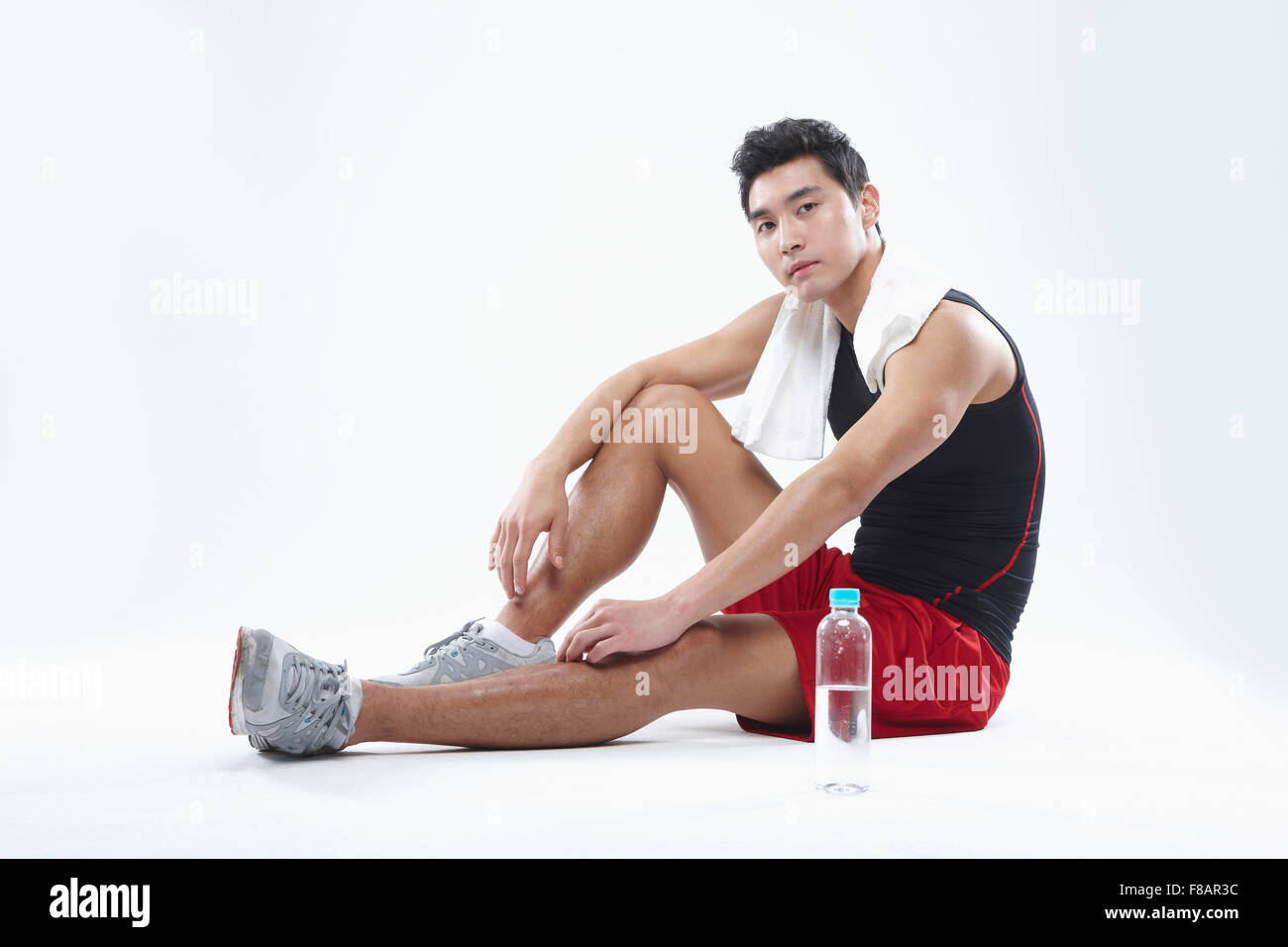 Mann in Sportbekleidung sitzen starrte auf Vorderseite mit Wasserflasche Stockfoto