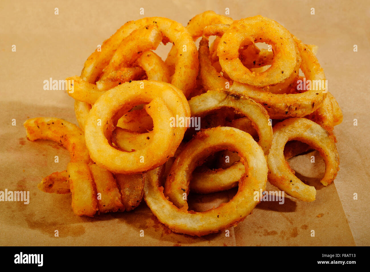 Curly Fries auf braunem Papierhintergrund Stockfoto