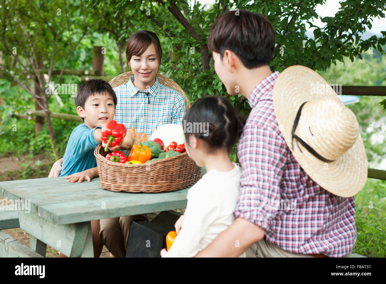 Porträt der glückliche Familie mit frischem Gemüse unter freiem Himmel am Tisch sitzen Stockfoto