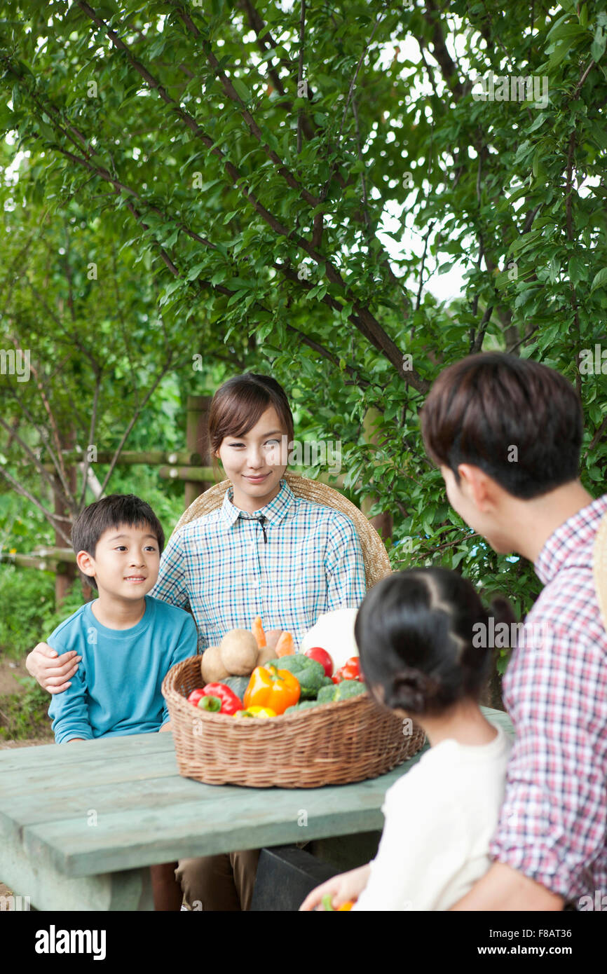 Glückliche Familie mit frischem Gemüse unter freiem Himmel am Tisch sitzen Stockfoto