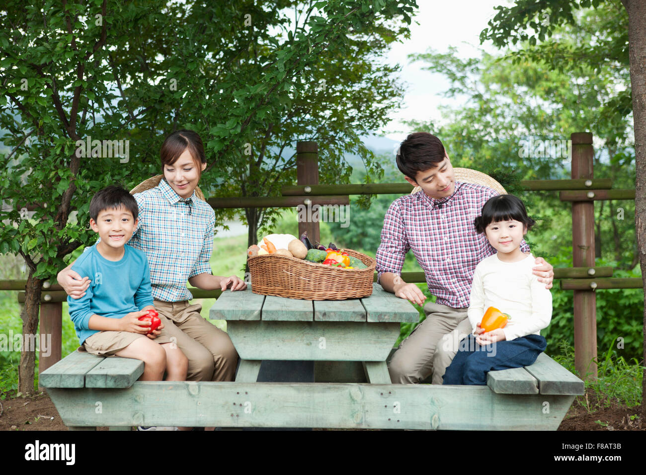Liebevolle Familie mit frischem Gemüse unter freiem Himmel am Tisch sitzen Stockfoto