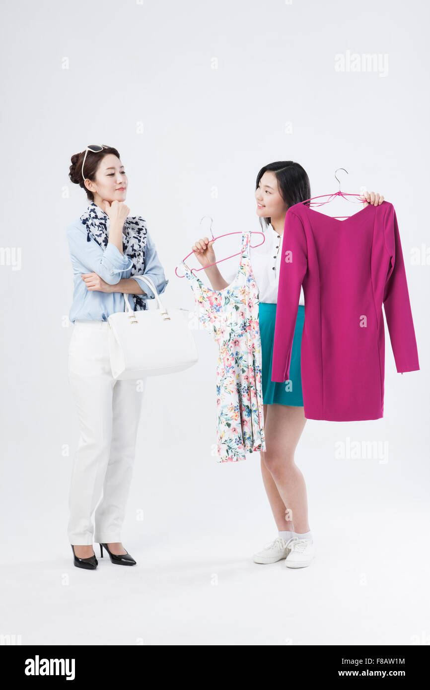Mutter und Tochter vergleicht man zwei Arten von Kleidern für den Einkauf Stockfoto