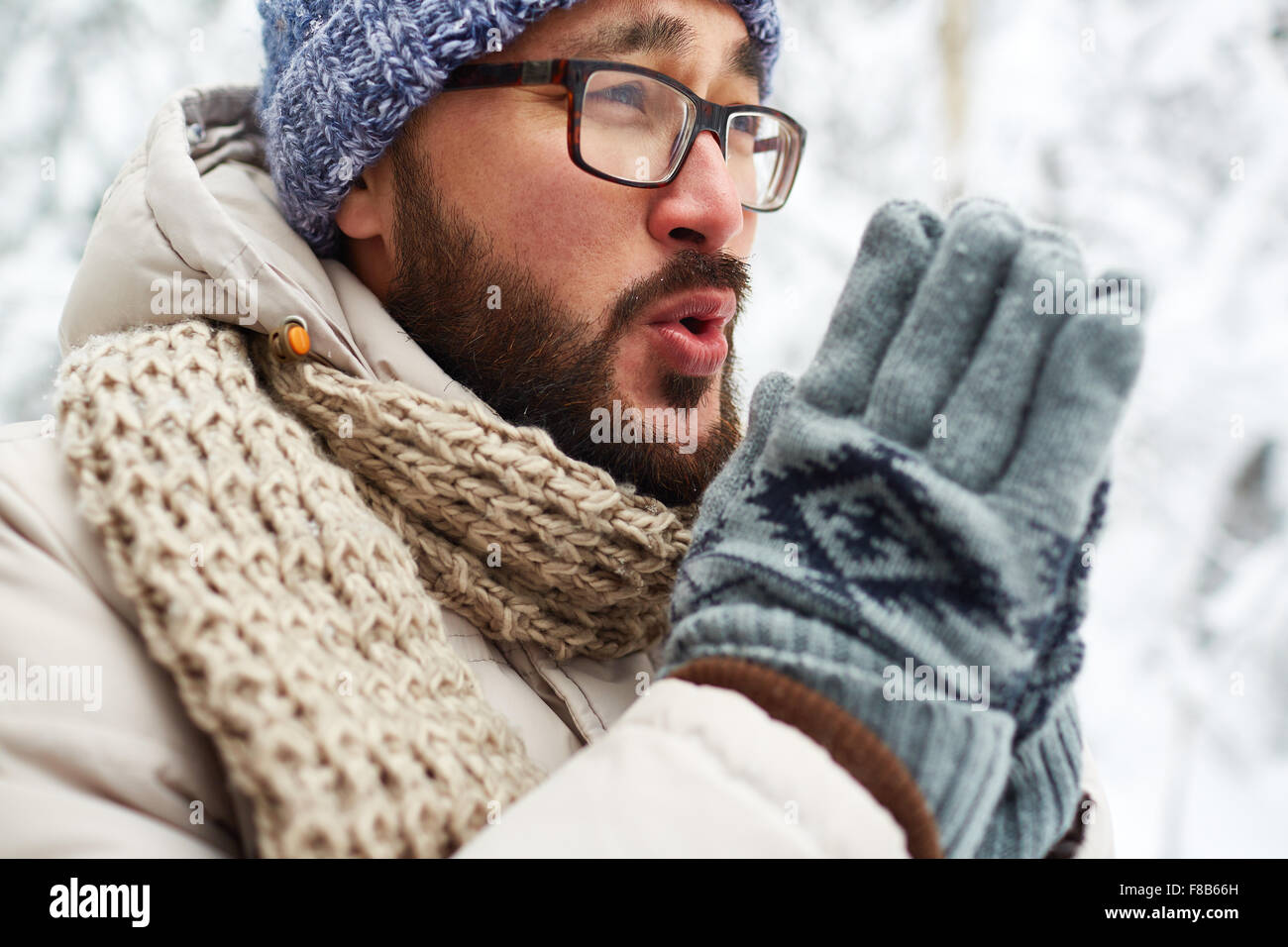 Asiaten in Winterwear und versucht, seine Hände außerhalb warme Handschuhe Stockfoto