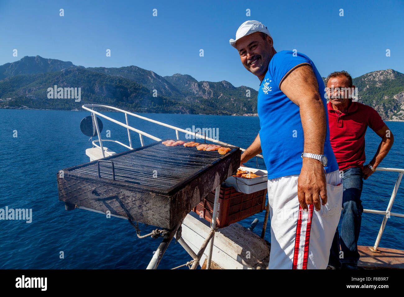 Boot-Mitarbeiter kochen ein Barbeque Mittagessen für Touristen während eine Boot Reise, Marmaris, Provinz Mugla, Türkei Stockfoto Boot-Mitarbeiter kochen ein Barbeque Mittagessen für Touristen während eine Boot Reise, Marmaris, Provinz Mugla, Türkei Stockfoto