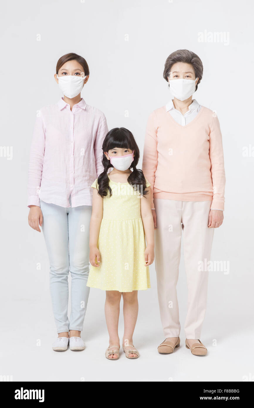 Mutter, Tochter, Enkelin alle medizinische Masken und starrte nach vorne Stockfoto