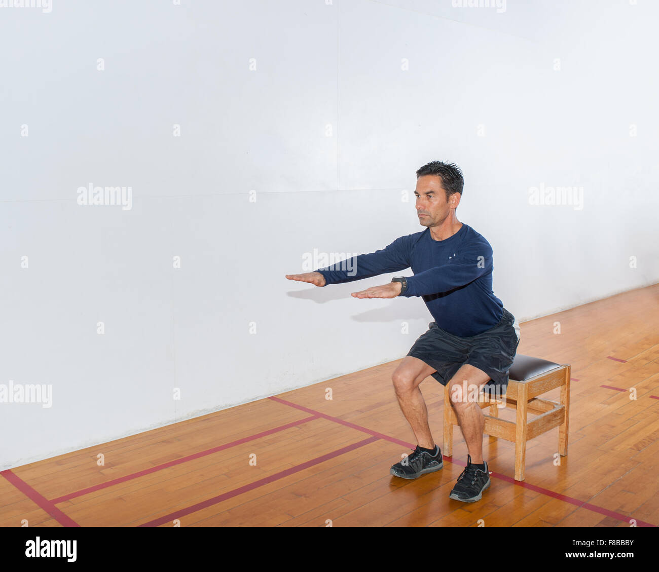 Mittleren Alter Mann zeigen Körper Gewicht Übung für die Beine Stockfoto