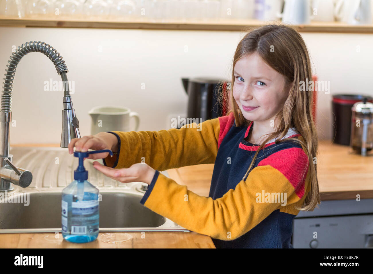 9 Jahre altes Kind waschen Sie ihre Hände mit hydroalkoholischen gel. Stockfoto