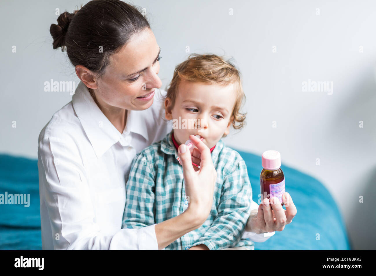 2 Jahre alter Junge unter Sirup mit Pipette. Stockfoto