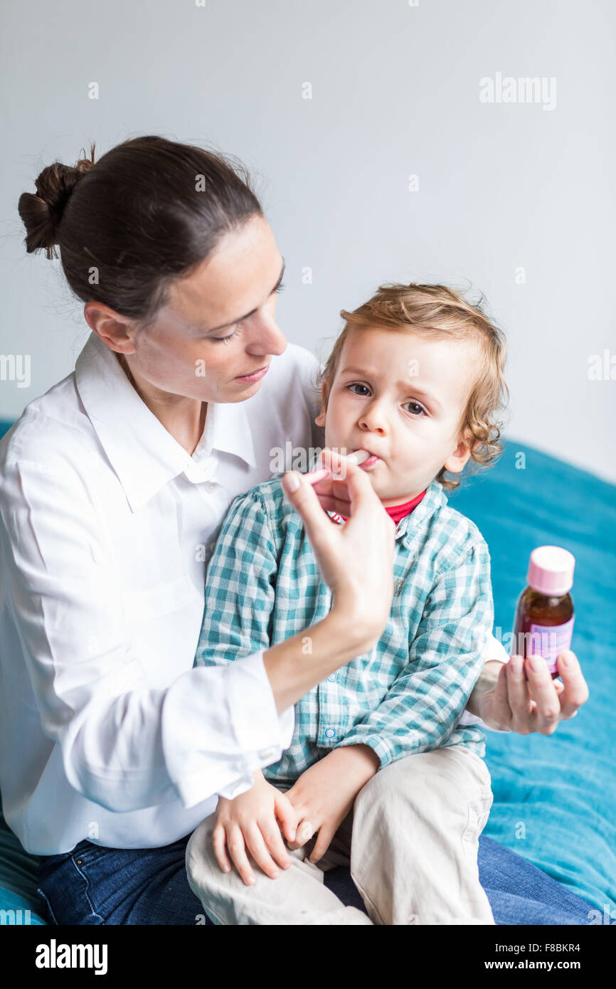 2 Jahre alter Junge unter Sirup mit Pipette. Stockfoto