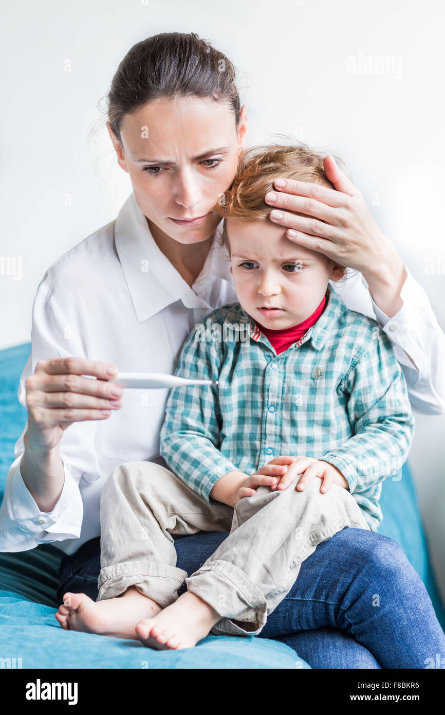 Mutter, überprüfen die Temperatur ihrer 2-jähriger Junge mit einem digitalen Thermometer. Stockfoto