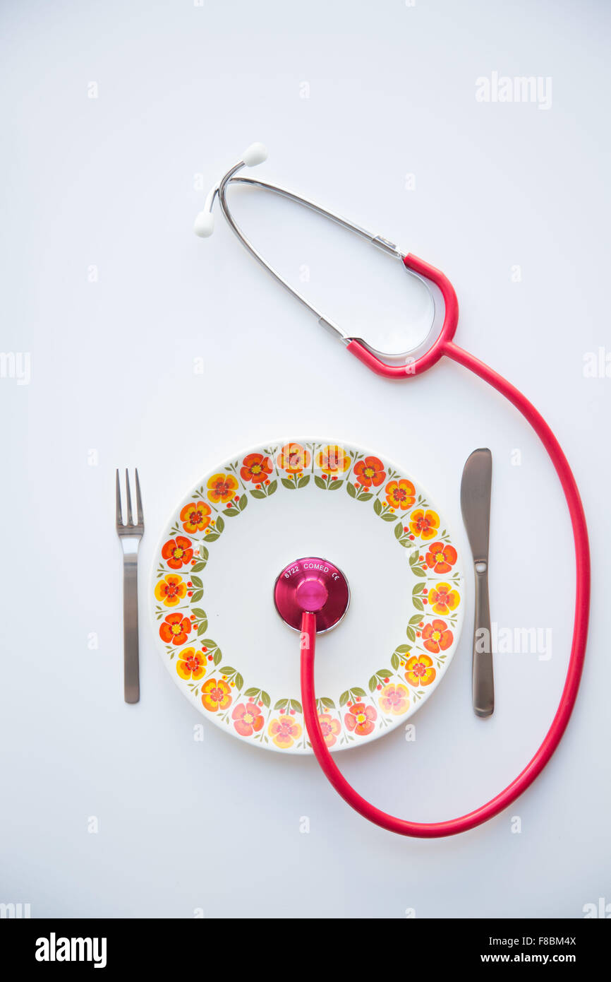 Stethoskop auf einem Teller. Konzeptbild über die Vorteile einer ausgewogenen Ernährung auf die Gesundheit. Stockfoto
