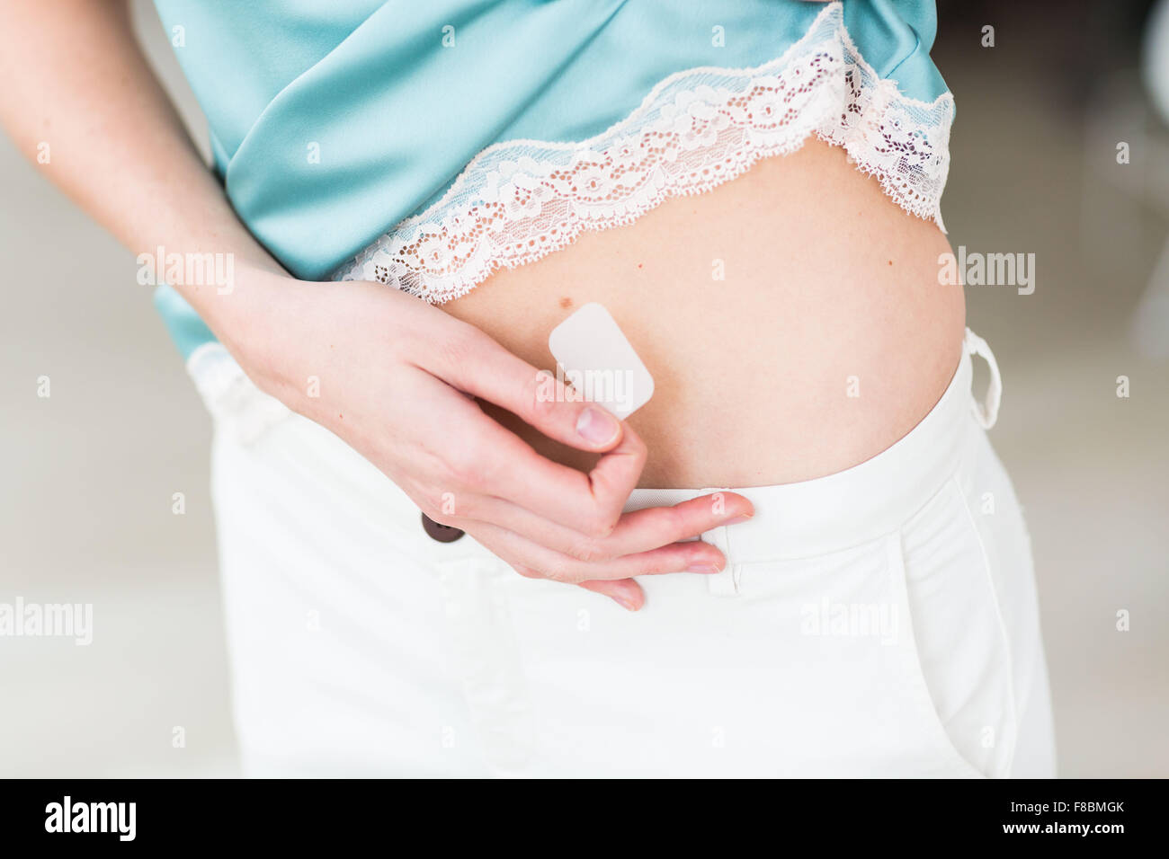 Frau anwenden eines Patches. Stockfoto