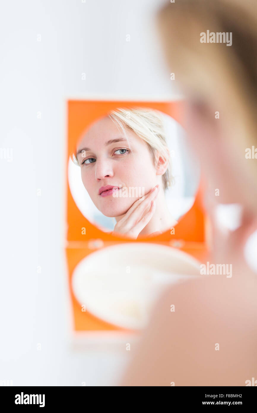 Frau ihr Gesicht im Spiegel zu überprüfen. Stockfoto