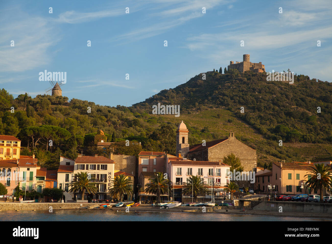Schönen Abendlicht auf die Stadt Collioure, Südfrankreich, mit der historischen Windmühle & Fort Saint-Elme im Hintergrund. Stockfoto