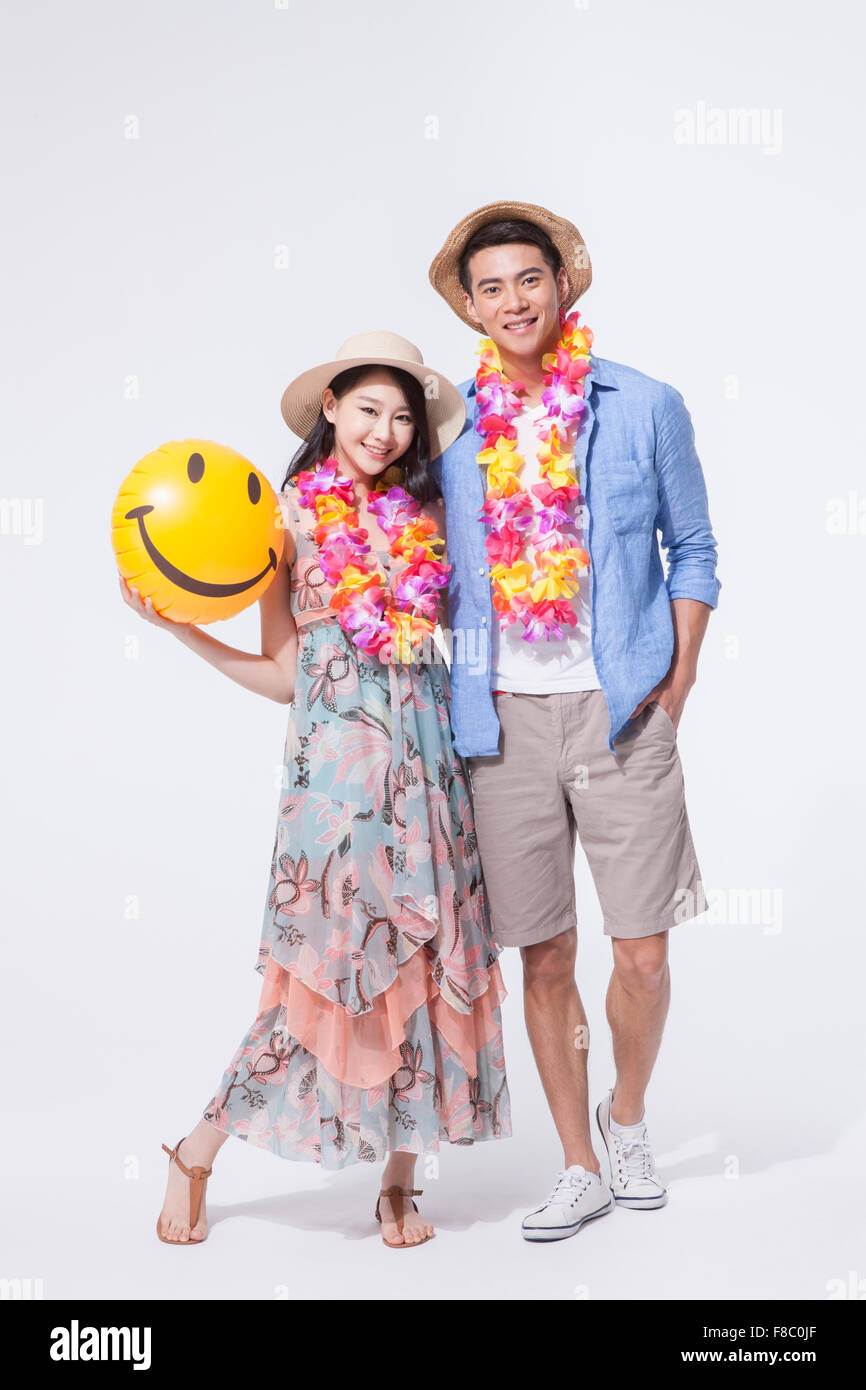 Mann in casual-Outfits und einen Hut-Stand mit einer Frau im langen Kleid hält einen Wasserball in einen Hut und starrte nach vorne mit Stockfoto