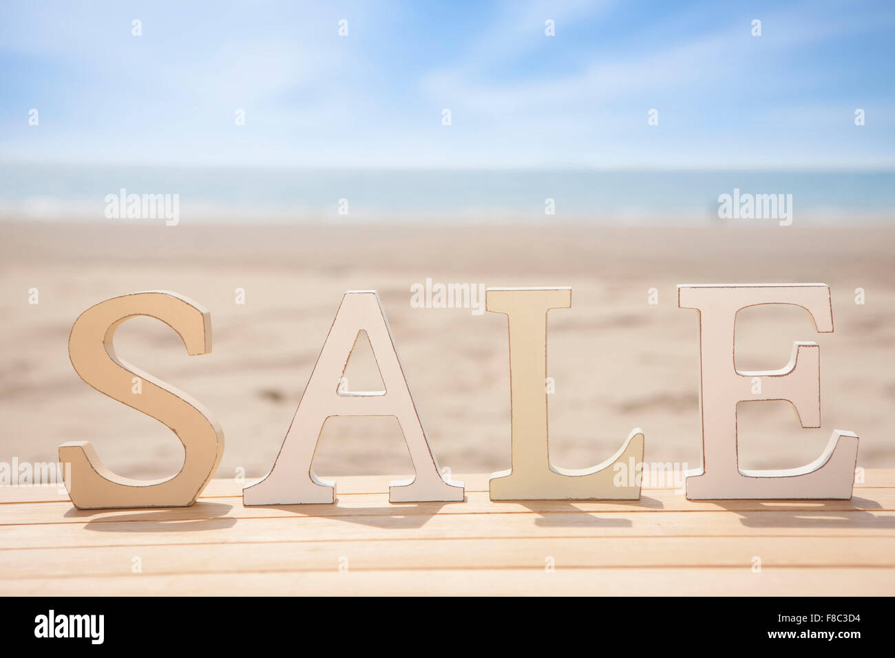 Solide Wort Verkauf stehend auf Holzwerkstoff mit dem Hintergrund des Strandes Stockfoto