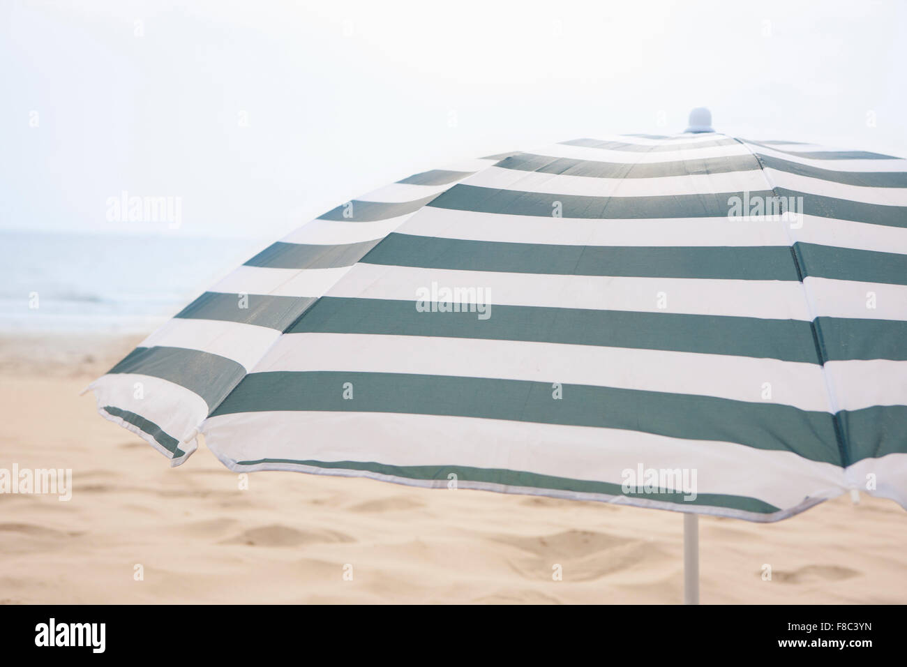 Strand Sonnenschirm außerhalb des Fokus mit dem Hintergrund des Strandes Stockfoto