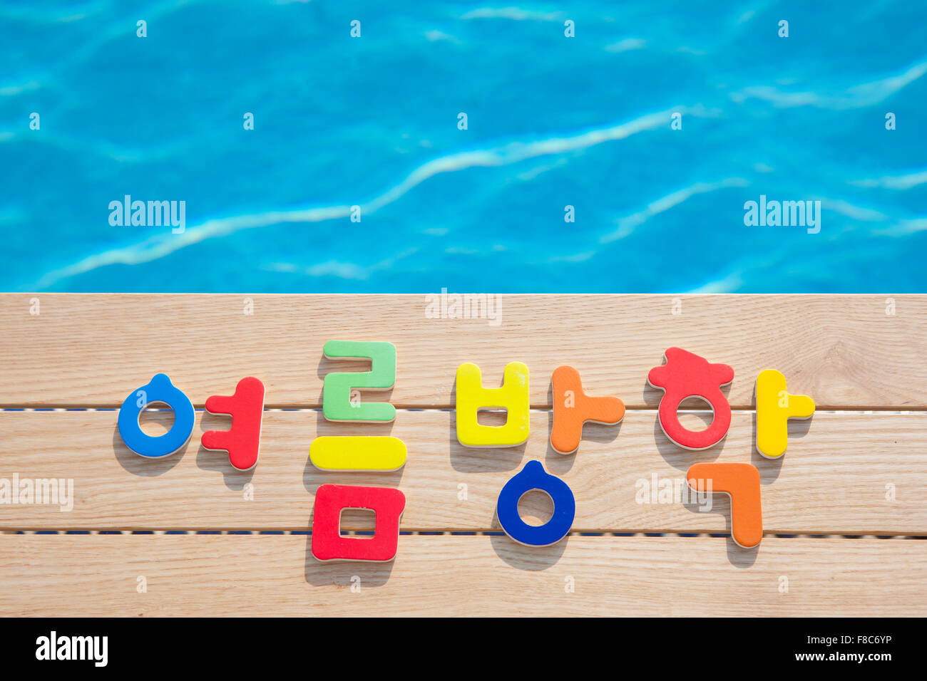 Hohen Winkel der koreanischen Buchstaben Bedeutung Sommerferien auf Holz mit dem Hintergrund des Wassers im pool Stockfoto