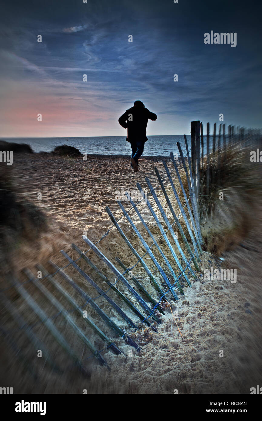 Mann läuft am Strand Stockfoto