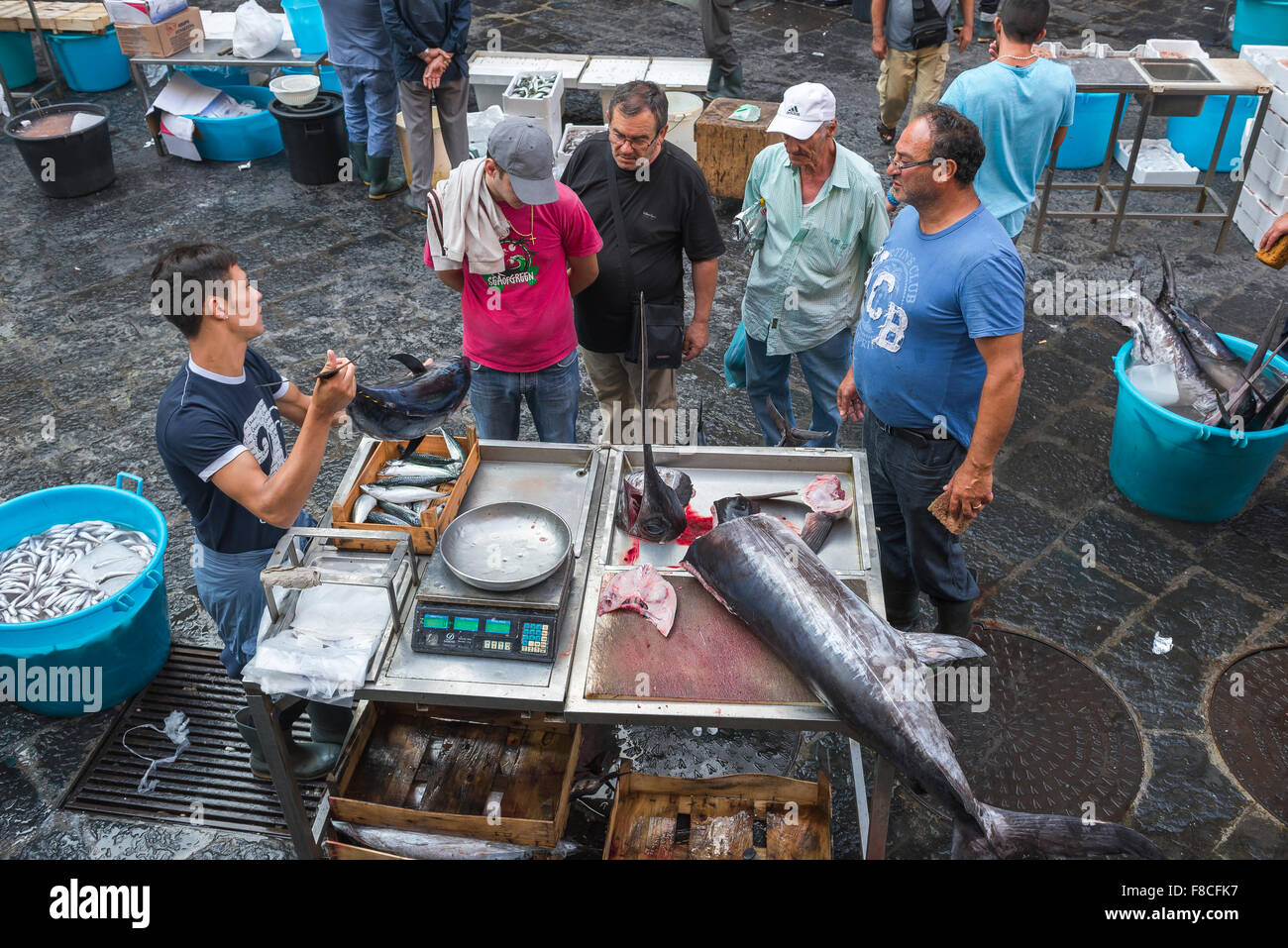 Mann kaufen Fisch, Blick auf die sizilianische Männer in einer Warteschlange Schwertfisch in der Stadt Fischmarkt zu kaufen (Mercato della Pescheria), in Catania, Sizilien. Stockfoto