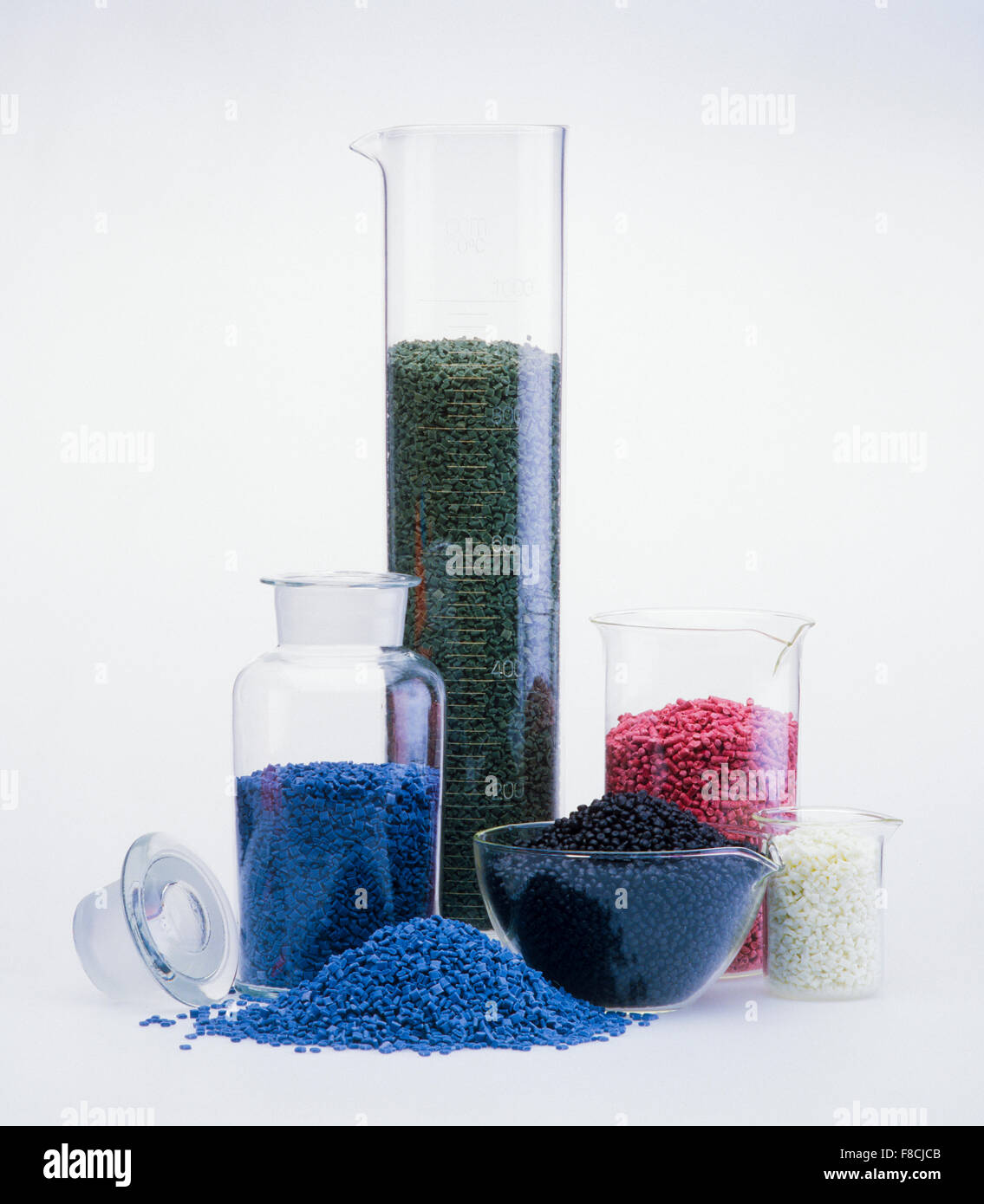 Granuliertes Kunststoffmaterial in chemischen Glasanlagen in einer Forschungsabteilung, isoliert auf Weiß Stockfoto