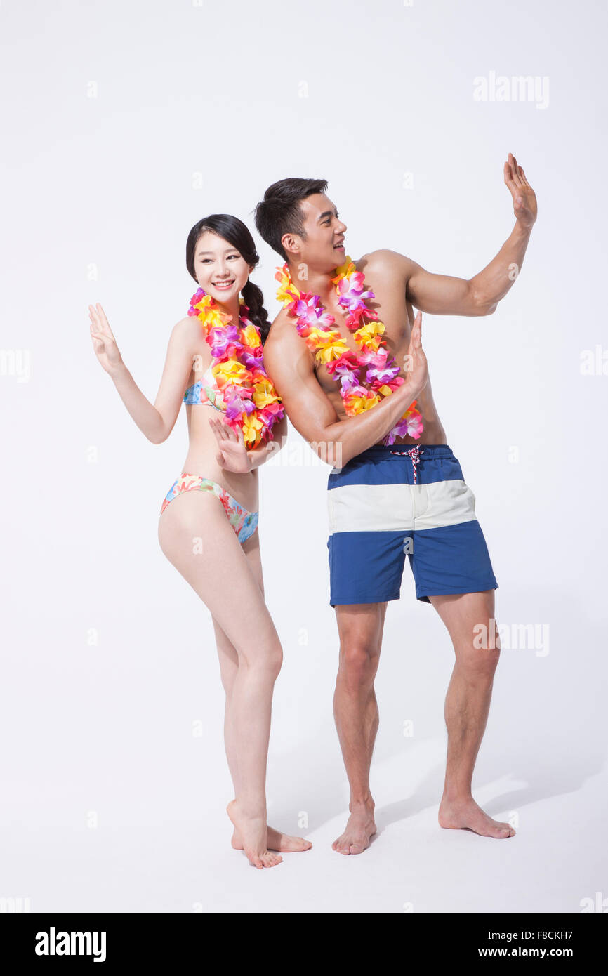 Paar in Strand tragen und eine Blume Halskette zusammen tanzen Stockfoto