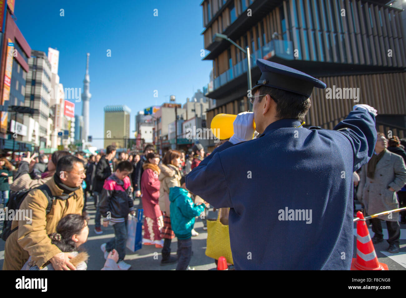 Polizist, die Durchführung von Tausenden von Menschen zu den Asakusa-Kannon-Tempel Stockfoto