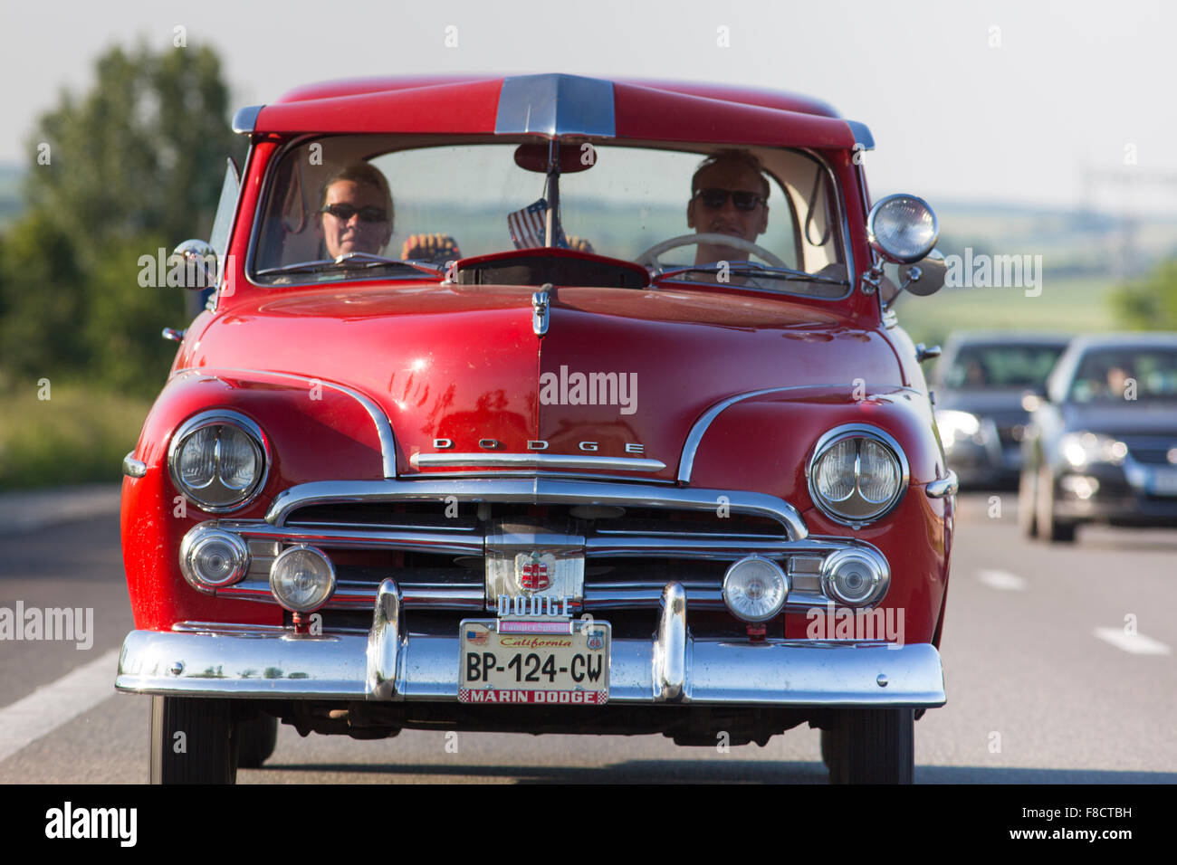 Mann und Frau in einem roten Dodge Oldtimer auf der Autobahn fahren Stockfoto