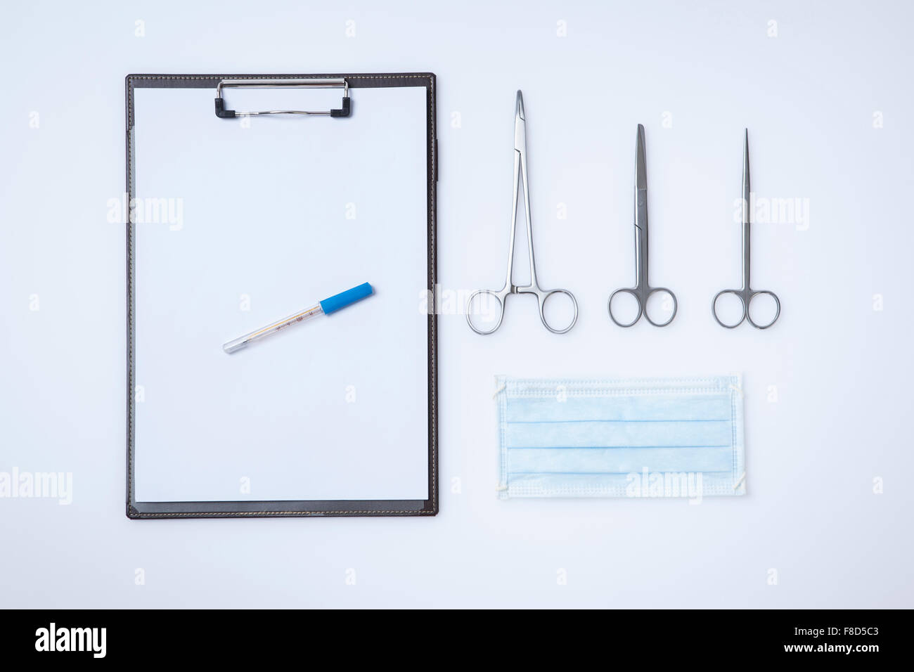 Kopieren Sie Raum von einem medizinischen Diagramm mit einem Stift neben verschiedenen Arten von Schere und eine Maske Stockfoto